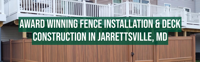 A backyard with a newly installed wood-style privacy fence and a raised white deck attached to a house. Overlaid text reads: “Award Winning Fence Installation & Deck Construction in Jarrettsville, MD.”