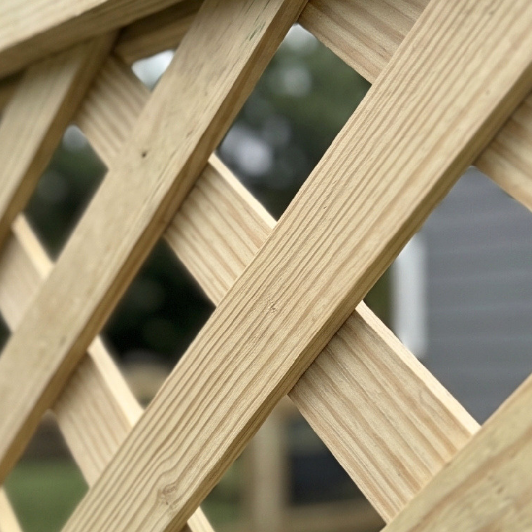 Close-up angled view of a custom wooden fence lattice, showcasing the diagonal intersecting woodwork, craftsmanship, and sturdy material thickness.