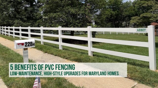 Long span of low-maintenance white PVC rail fencing installed along a green residential lawn, sidewalk, and mailpost in Maryland